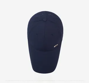 Macro shot of breathable mesh texture and golden metal logo on navy outdoor baseball cap