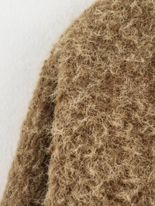 Close-up of brown plush fabric showing premium fluffy long-pile texture and fiber details