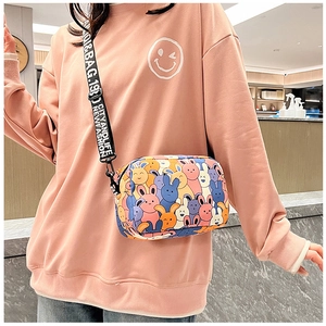 Close-up of colorful cartoon rabbit pattern and wide lettered shoulder strap on square bag