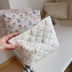 Detailed macro view of quilted cotton makeup bag with bear floral prints and zipper closure