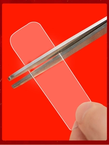 Close-up of transparent double-sided adhesive strip held with tweezers on red background