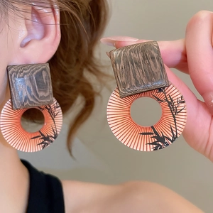 Detailed close-up of vintage square wood and resin fan earrings worn on model's ear