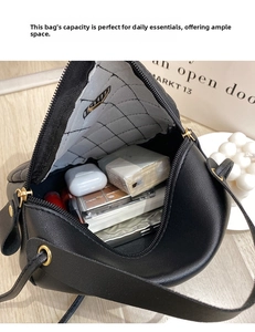 Top view of spacious interior of black quilted crossbody bag with daily essentials