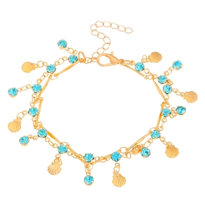 Golden shell bracelet with sky blue zircon stones and seashell charms on white background