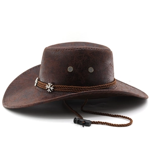Détail d'un chapeau de cowboy marron avec clou en croix argentée et bande tressée rétro