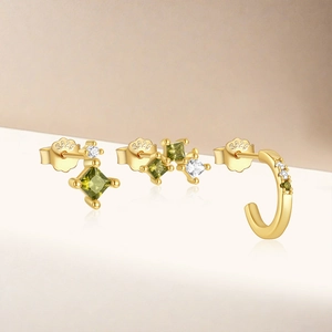 Detailed macro of S925 sterling silver gold earrings with green and clear zircon stones