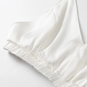 Détail d'un caraco en satin blanc avec ourlet élastique et texture douce soyeuse