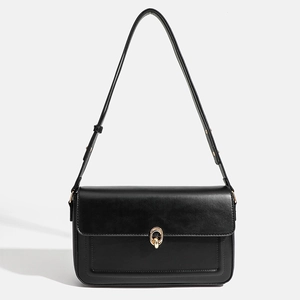 Minimalist black leather crossbody bag with vintage gold buckle and adjustable strap