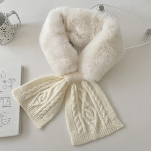 Detail of white faux fur and cable knit scarf texture in a cozy winter setting