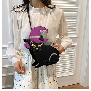 Détail du sac bandoulière chat noir avec chapeau de sorcier violet sur un mannequin