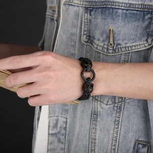Punk skull bracelet in matte black finish on male wrist with denim jacket sleeve
