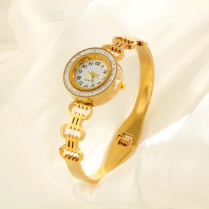 Elegant gold stainless steel watch with zircon bezel and hollow bracelet on white silk