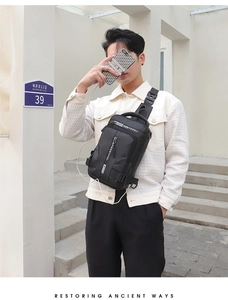 Detail showing the external USB charging port on a black waterproof crossbody sling bag