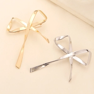 Polished gold and silver metal bow brooches in a minimalist dual-set design