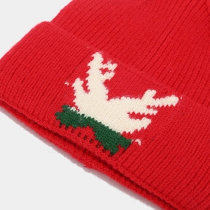 Close-up of thick red knitted Christmas hat with elk antler jacquard pattern detail
