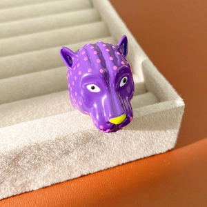 Gros plan détaillé d'une bague tête de léopard violette avec des pois roses et nez jaune
