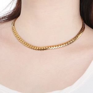 Close-up of a 18K gold-plated flat Cuban link chain necklace on a model's neck