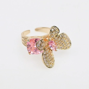 Elegant gold butterfly open ring with pink zircon stones on white background