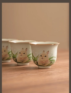 Detailed view of hand-painted rabbit motifs on Ru-kiln ceramic teacups with crackle glaze