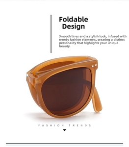 Detail view of foldable sunglasses with amber frames and silver rivets in a compact state