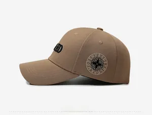 Detail of khaki baseball cap featuring 3D letter embroidery and compass side patch
