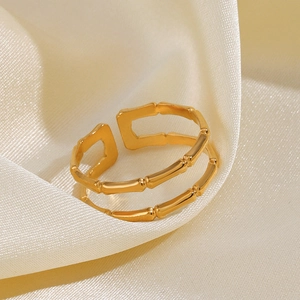 Bague réglable à double couche en forme de bambou dorée sur fond de soie beige clair
