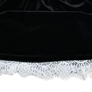 Détail de l'ourlet de la robe en velours noir avec bordure en dentelle blanche