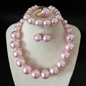 Detail of pink pearl jewelry set including necklace, earrings and ring on mannequin