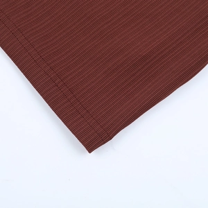 Vue détaillée du tissu en maille côtelée marron foncé montrant les finitions de l'ourlet