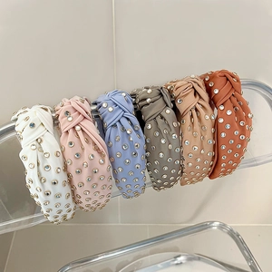 Detail of knotted headbands with rhinestones in ivory, pink, blue, grey, and orange colors