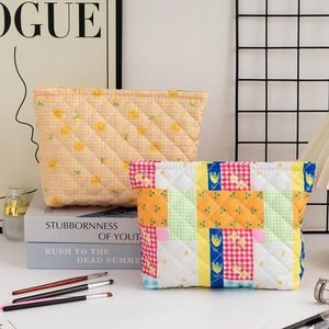 Detailed view of quilted cotton cosmetic bags in yellow plaid and rainbow patchwork styles