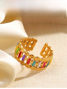 Close-up of golden hollow-out ring featuring vibrant colorful enamel inlay details