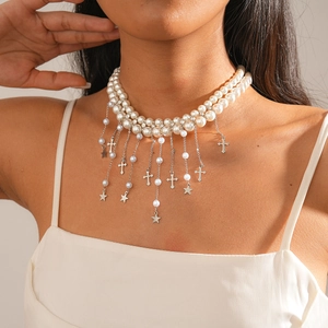 Détail d'un collier de perles double épaisseur avec pendentifs croix et étoile