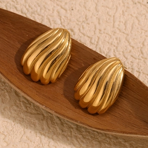 Détail d'une boucle d'oreille plaquée or 18K avec rayures et texture de coquillage