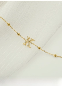 Detailed macro view of gold titanium steel K-letter pendant with zircon stones