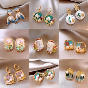 Collage of vintage floral earrings with freshwater pearls and gold metal on silk fabric