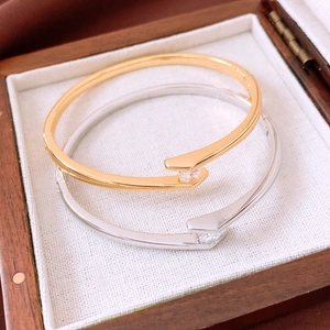 Close-up of gold and silver minimalist open bangles with zircon in a wooden box