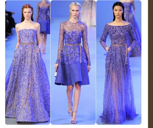 Detail view of thin gold belts styling elegant purple lace floral dresses on runway