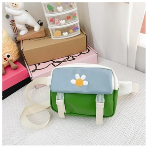 Detail of color-block green and blue kids' crossbody bag with daisy embroidery pattern
