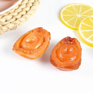 Lifelike PVC abalone food model with lemon slices on a woven mat for food photography