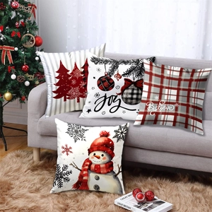 Set of 4 Christmas pillow covers with snowman and tree designs on a gray sofa