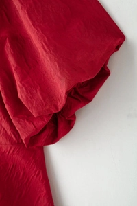 Détail du tissu tissé rouge avec plis naturels et savoir-faire de couture exquis
