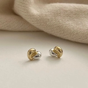 Minimalist 925 silver knot earrings in mixed gold and silver colors on woven fabric