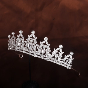 Side view detail of silver bridal crown with crystal rhinestones on brown velvet