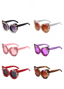 Detail of six colorful cat-eye sunglasses with rhinestone-studded frames and floral accents