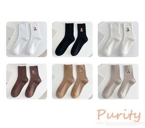 Gros plan de chaussettes en coton en six tons terre avec broderie d'ours mignonne