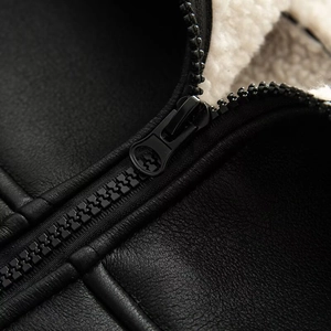 Close-up of durable metal zipper and soft white lamb wool lining on black leather jacket