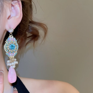 Detailed close-up of vintage resin drop earrings with crystal and floral tassel accents