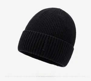 Close-up of black ribbed knit beanie featuring a branded label and warm folded cuff detail
