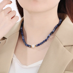 Detail of beaded necklace with 6mm blue sodalite beads and white pearl on model